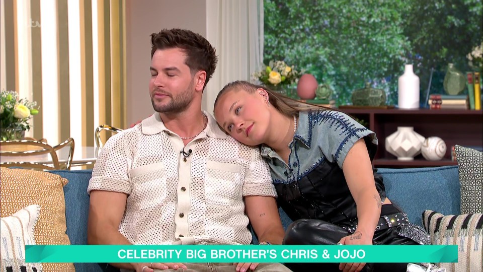 Chris Hughes and JoJo Siwa on a talk show sofa.