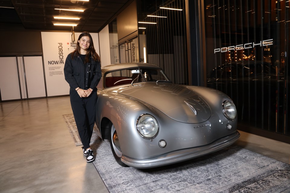 Emma Raducanu standing next to a vintage Porsche.