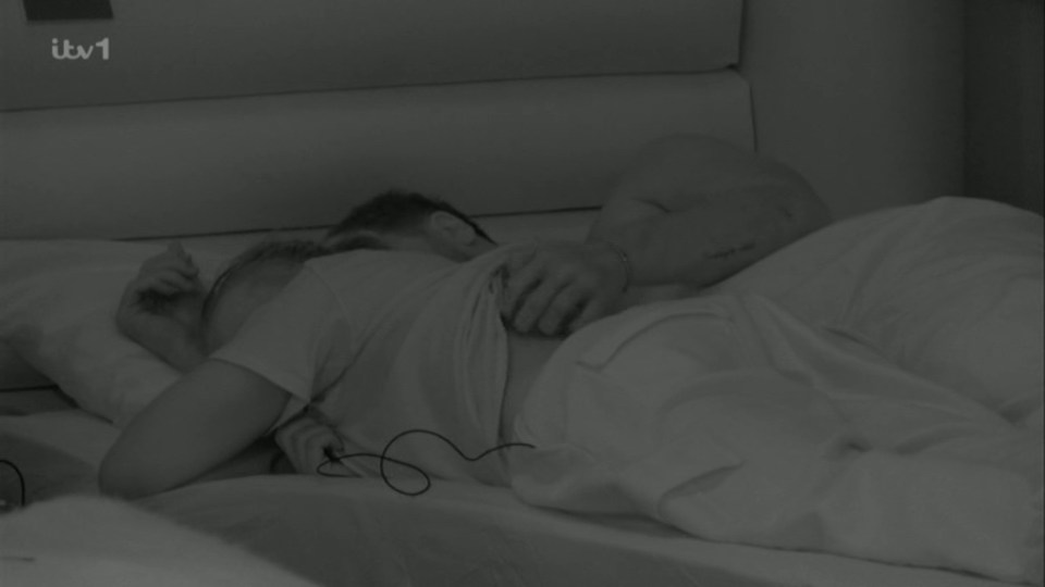 Two people cuddling in bed.