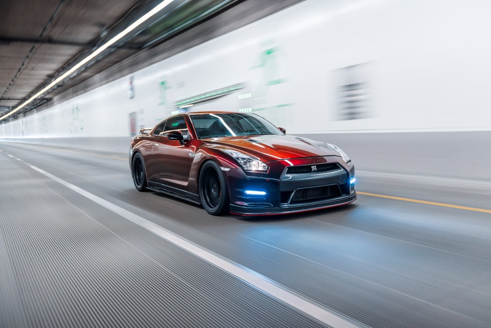 A red sports car speeding through a tunnel.