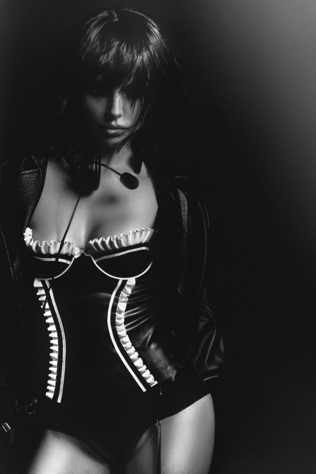 Black and white portrait of Maura Higgins wearing a black leather jacket and a black and white bodysuit.