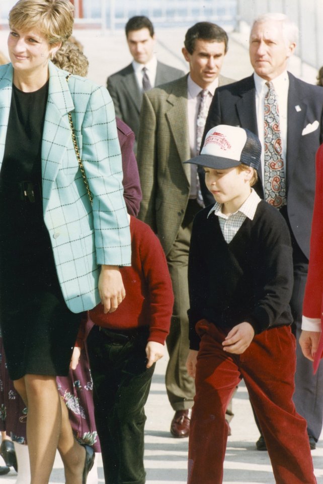 Princess Diana and Prince William walking with a bodyguard.