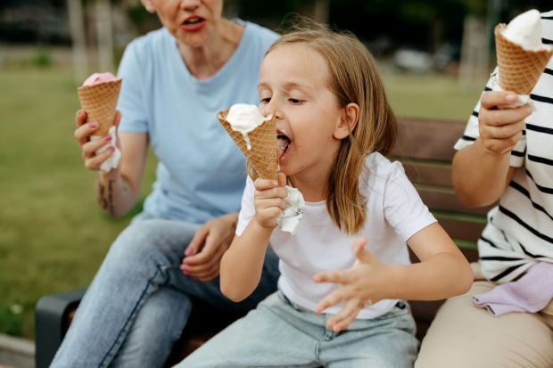 An image collage containing 1 images, Image 1 shows Three generations of women enjoy ice cream cones together on a park bench