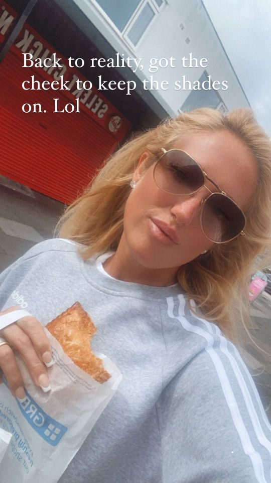 Woman wearing sunglasses eating a pastry.