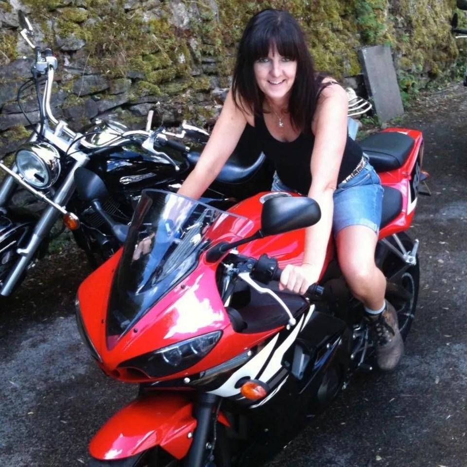 Woman sitting on a red motorcycle.