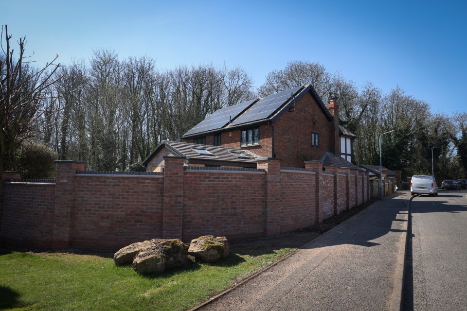 A newly built brick wall between houses on a residential street.