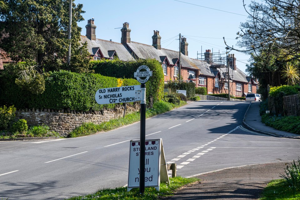 Studland village road sign and houses.