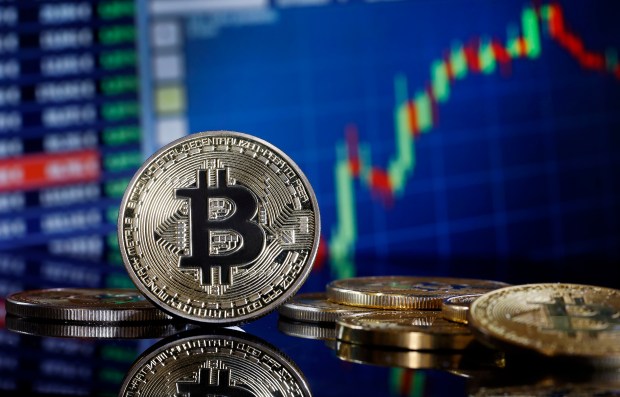 Photo illustration of Bitcoin in front of a stock chart.