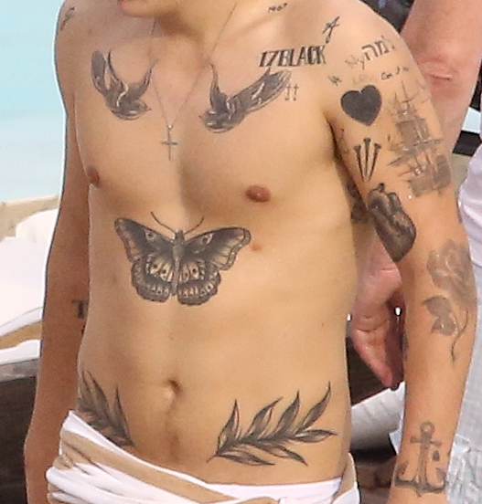 Harry Styles shirtless with tattoos in music video.