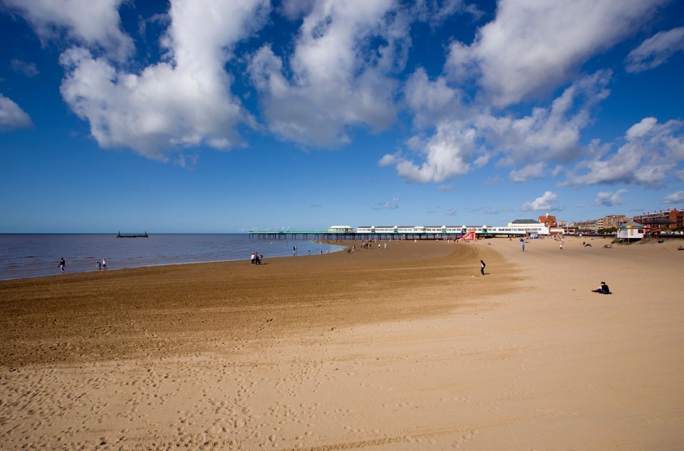 Lytham St Annes beach with pier and people.