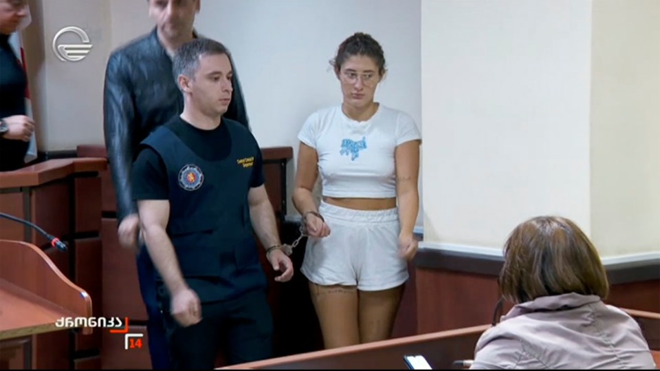 A handcuffed woman in court.