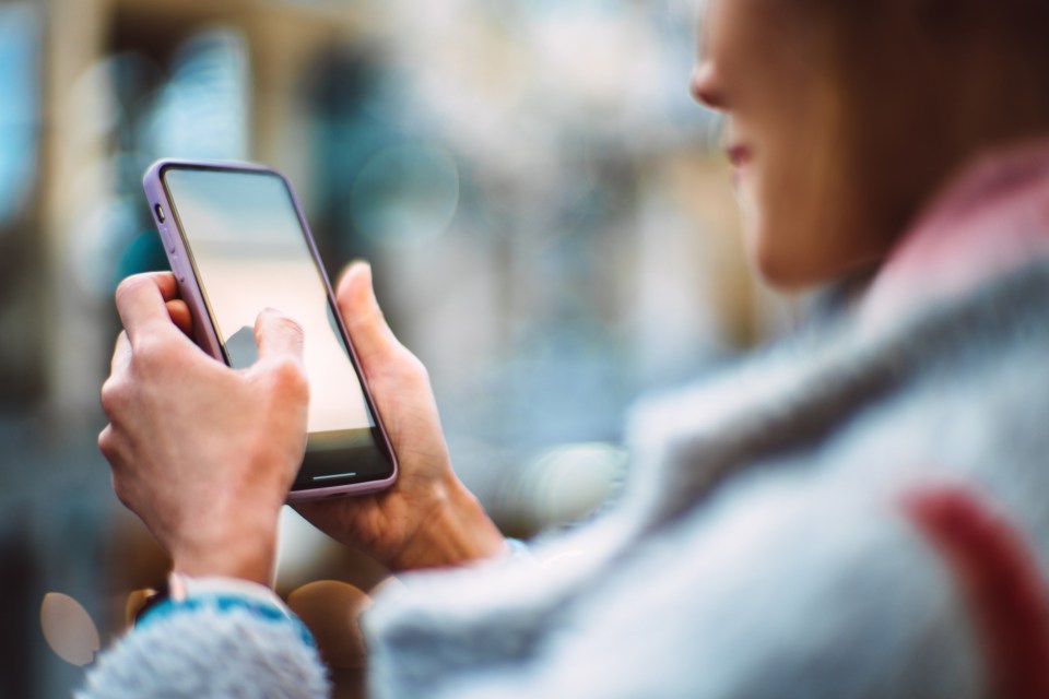 Woman using smartphone at a cafe.