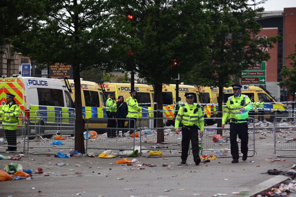 Police officers at the scene of a car collision during a Liverpool victory parade.