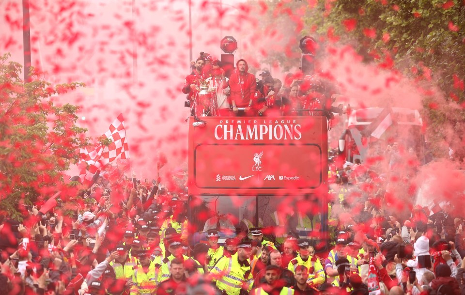 Liverpool players celebrating with fans in a victory parade.