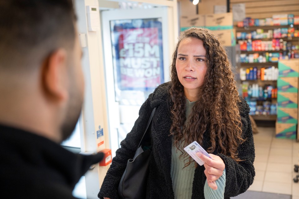 Woman showing ID to clerk.