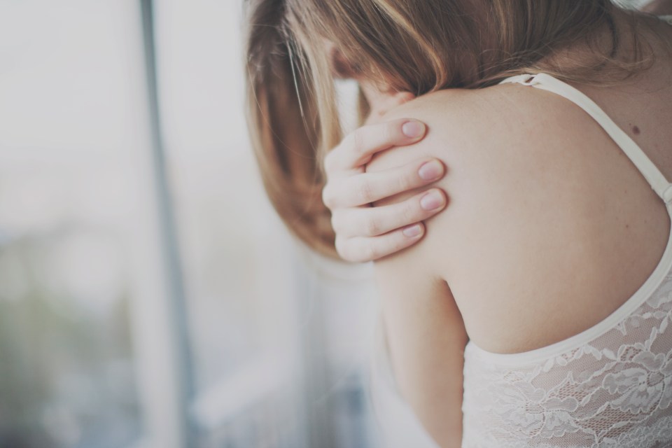 Woman hugging herself.