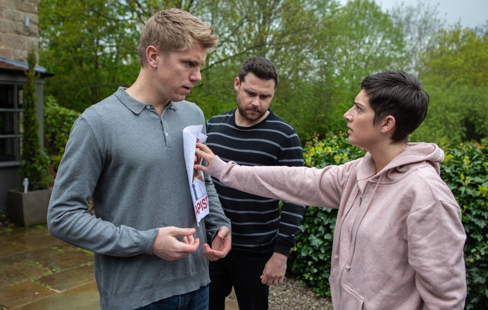 Three people reacting to a poster that says "rapist".