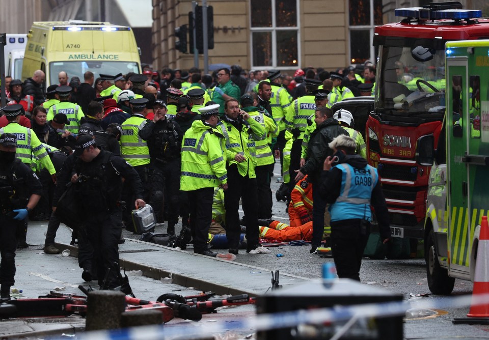 Emergency responders attending to a person injured during a parade.
