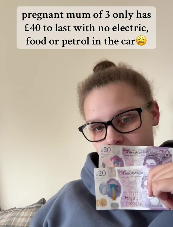Pregnant mother of three holding two twenty-pound notes, stating she has no electricity, food, or petrol.